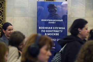 Los pasajeros pasan junto a una pancarta en la que se recluta personal para el servicio en las Fuerzas Armadas rusas, instalada en la estación Smolenskaya del metro de Moscú el 19 de agosto de 2025, en Moscú, Rusia. (Fuente: Getty Images)