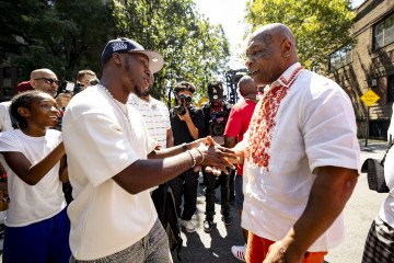 Mike Tyson, wearing a Ukrainian vyshyvanka, greets WBC featherweight champion Bruce “Shu Shu” Carrington before the Brownsville Boxing Legends Peace Parade in Brooklyn, August 15, 2026. (Source: Getty Images) Mike Tyson, wearing a Ukrainian vyshyvanka, greets WBC featherweight champion Bruce “Shu Shu” Carrington before the Brownsville Boxing Legends Peace Parade in Brooklyn, August 15, 2026. (Source: Getty Images)