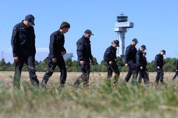 Police officers are searching a field at Leipzig/Halle Airport for evidence, following the drone incident on August 5. (Source: Getty Images)