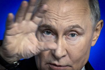 Russian leader Vladimir Putin gestures as he speaks during his annual end-of-year press conference, in Moscow, on December 19, 2025.