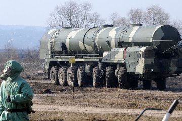 Russian soldier wearing a chemical protection suit next to a military fueler on the base of a prime mover of a Russian Topol intercontinental ballistic missile, some 100km outside Moscow on April 6, 2010. Russian soldier wearing a chemical protection suit next to a military fueler on the base of a prime mover of a Russian Topol intercontinental ballistic missile, some 100km outside Moscow on April 6, 2010.