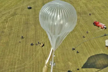 A Russian high-altitude stratospheric balloon being prepared for launch in an open field, with ground crew and support vehicles positioned nearby. (Source: TV Zvezda)