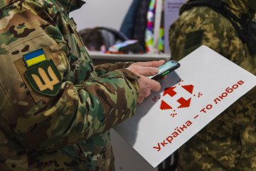 Illustrative image. Ukrainian soldier holding a Nova Poshta postal package.