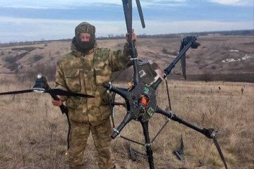Russian soldier standing with a downed Ukrainian Vampire heavy bomber drone. Russian soldier standing with a downed Ukrainian Vampire heavy bomber drone.