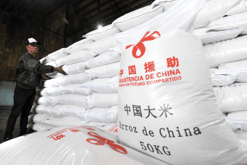 Bags of rice marked “Assistance from China” are stacked at a warehouse in China. (Source: South China Morning Post)