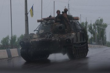 Ukrainian servicemen drive on an armored vehicle along a road covered with an anti-drone mesh corridor on May 17, 2026, in Druzhkivka, Donetsk region, Ukraine. Ukrainian servicemen drive on an armored vehicle along a road covered with an anti-drone mesh corridor on May 17, 2026, in Druzhkivka, Donetsk region, Ukraine.