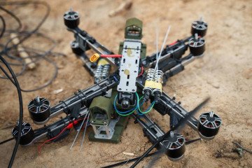 A Ukrainian FPV strike drone equipped with an explosive payload and camera module lies on the ground during testing. (Source: Ukrainian Ministry of Defense)