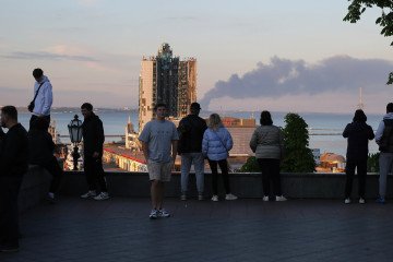 People standing on Primorsky Boulevard look at the smoke rising from a Russian missile attack on Odesa Marine Station on the afternoon of April 19, 2024. Illustrative photo. (Source: Getty Images)