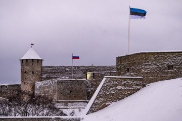 A Estonian flag flutters in front of a Russian flag flying over the Russian Fortress of Ivangorod on the opposite bank of the Narva River in Narva. (Source: Getty Images)