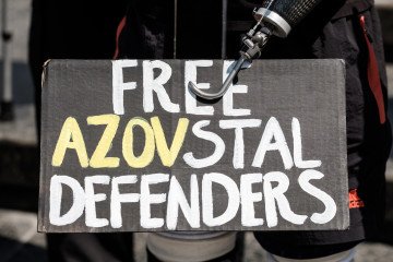 Wounded veteran holds banner that reads “Free Azovstal Defenders” urging for the return of Ukrainian soldiers from Russian captivity on May 31, 2025 in Lviv, Ukraine. (Source: Getty Images)