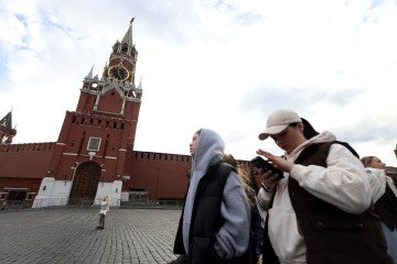 A woman attempts to access the internet using his smartphone while walking near the Kremlin, on March 31, 2026, in Moscow, Russia. (Source: Getty Images)
