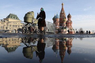 A woman with a baby stroller walks past Saint Basil's Cathedral at the Red Square on February 28, 2024, in Moscow, Russia. (Source: Getty Images)