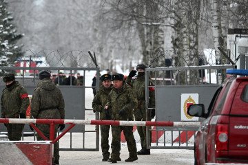 Servicemen are seen at the gate to the grounds of an army base where a military police building collapsed. (Source: Getty Images)