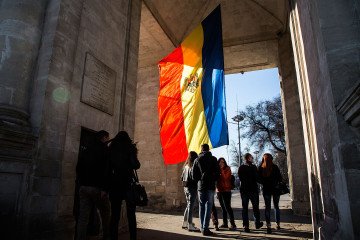 People gather at the Moldovan national flag at the parliament building. (Source: Getty Images)