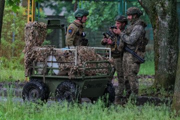 Ukrainian servicemen stand next to an unmanned ground vehicle on May 17, 2026 in Druzhkivka, Donetsk Oblast, Ukraine. (Source: Getty Images)