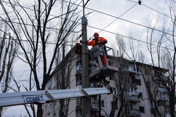 Utility workers on platform of cherry-picker truck conduct repair work of communication line at residential district after a Russian combined strike. (Source: Getty Images)