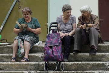 Pensioners queue outside the post office to withdraw their monthly payouts in the Ukrainian port city of Mariupol, which is temporarily occupied by Russian forces, on July 18, 2022. (Source: Getty Images)