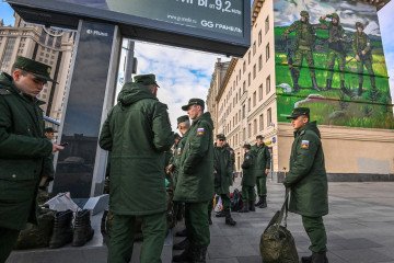 Russian soldiers wait for their departure as they stand near a mural depicting Russian servicemen wearing “Z” symbol armbands, close to the Paveletsky railway terminal, in central Moscow on October 16, 2022. Illustrative image. (Photo: Getty Image)