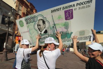 Members of a social network group carry a one-thousand ruble banknote with Putin’s face in Moscow on August 18, 2011. Members of a social network group carry a one-thousand ruble banknote with Putin’s face in Moscow on August 18, 2011.