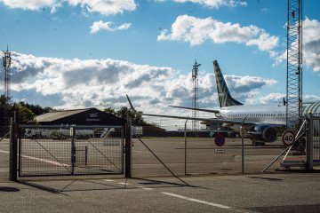 A passenger aircraft behind security fencing, suspected drone sightings at Aalborg Airport in Norresundby, Denmark, on September 26, 2025. (Source: Getty Images)