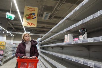A woman looks at empty shelves in the sanitary napkin section at a shopping mall on March 16, 2022, in Moscow, Russia. (Source: Getty Images)