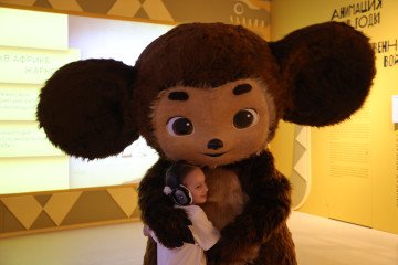 A young girl embraces a performer dressed as Cheburashka, a Soviet-era cartoon character at the "Live Together" exhibition May 15, 2023 in Moscow, Russia. (Photo: Getty Images)