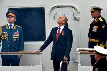 Russia’s leader, Vladimir Putin, and Defence Minister watch the Russian Air Force parade during their visit to the Crimean port of Sevastopol on May 9, 2014. (Source: Getty Images)