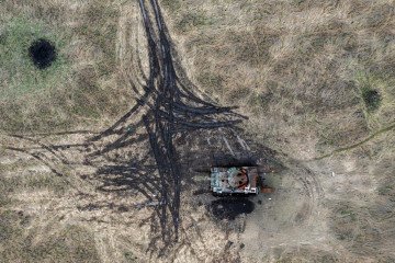 Tanque ruso destruido entre cráteres de artillería en Kamyanka, región de Kharkiv, Ucrania.