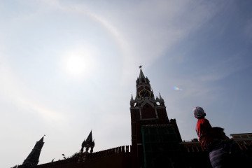 Russians walk near the Kremlin on Red Square under the clear blue skies of Moscow on August 13, 2010. Russians walk near the Kremlin on Red Square under the clear blue skies of Moscow on August 13, 2010.
