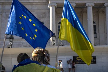 A person with a Ukrainian flag and another with the European flag are seen during a gathering in downtown Lisbon to protest against the ongoing Russian invasion of Ukraine in Lisbon, Portugal, on August 30, 2025. (Source: Getty Images)