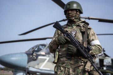 A Russian soldier stands armed in front of a military helicopter marked with the letter “Z,” a symbol associated with Russian forces operating in Ukraine. Illustrative photo. (Photo: Russian media)