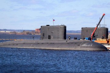 Russian Project 06363 “Mozhaysk” (B-608) and Project 877EKM “Dmitrov” (B-806) submarines fitted with cage armor, a mounted machine gun, and additional modifications to counter drone threats. (Source: Defense Express)