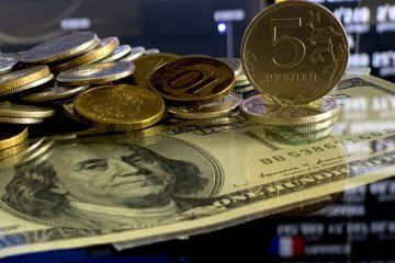 Russian ruble coins and one hundred dollars are seen on a table. (Source: Getty Images)