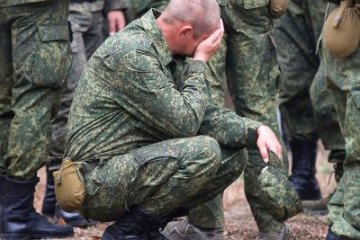 A Russian serviceman crouches among fellow troops during military training. (Photo: Open source)