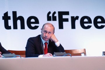 Putin, rests his head on his hand as he listens to calls from the world's publishers for a free and independent press in Russia