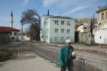 A man carrying a cabbage walks in the historic district as the Orta Juma Jami Mosque and a statue of Russian poet Alexander Pushkin are visible behind on March 9, 2014 in Bakhchysarai. Illustrative image. (Photo: Getty Images)