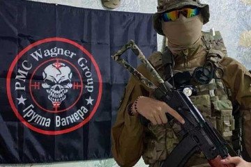 A suspected Wagner Group fighter poses with a rifle in front of a Wagner flag. (Photo: Open source) A suspected Wagner Group fighter poses with a rifle in front of a Wagner flag. (Photo: Open source)