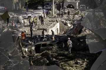 Local residents inspect cars burned in a Russian overnight missile and drone attack in Kyiv, Ukraine, on August 20, 2026. (Source: Getty Images)