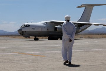 A man walks toward an Ilyushin Il-76 aircraft carrying supplies from the United Arab Emirates at the Port Sudan airport, on May 5, 2023.