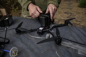 A Ukrainian soldier of the Black Wing unit, 116th Mechanized Brigade, tests an FPV drone at a workshop facility in an undisclosed location near the front line of eastern Ukraine, Kharkiv region, on October 8, 2025. (Source: Getty Images)