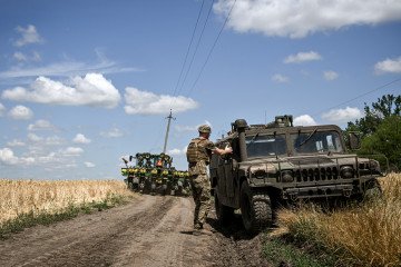 A tractor moves along the road past an HMMWV truck as a soldier heads for a position of a CAESAR self-propelled howitzer crew in Dnipropetrovsk region, Ukraine, on June 23, 2026. (Source: Getty Images) A tractor moves along the road past an HMMWV truck as a soldier heads for a position of a CAESAR self-propelled howitzer crew in Dnipropetrovsk region, Ukraine, on June 23, 2026. (Source: Getty Images)
