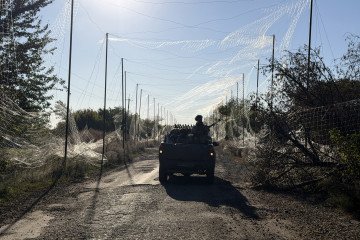 A serviceman of Ukraine’s 141st Separate Mechanised Brigade rides in a pickup vehicle under the anti-drone net in Prosyana village in Dnipropetrovsk region on October 2, 2026.