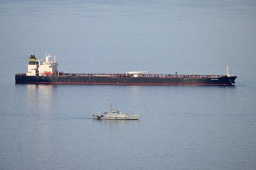 Military ships patrol the Smyrtos vessel outside the harbour, on June 14, 2026, in Portland, England.