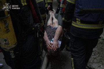 Emergency responders evacuate an injured resident from a building damaged in a Russian drone strike on Kyiv’s Pecherskyi district on September 25, 2026. (Source: SES)