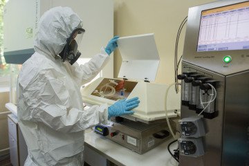 A lab technician wearing personal protective equipment (PPE) inspects a chemical reactor containing vaccine material at the Gamaleya National Research Center in Moscow, Russia, on August 6, 2020.