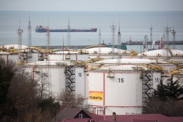 Oil storage tanks stand at the RN-Tuapsinsky refinery, operated by Rosneft Oil Co., as a tanker sails beyond in Tuapse, Russia. (Source: Getty Images)