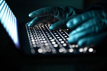 A person types with gloved hands on an illuminated laptop keyboard. Illustrative image. (Source: Getty Images) A person types with gloved hands on an illuminated laptop keyboard. Illustrative image. (Source: Getty Images)