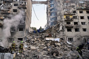 Ukrainian rescuers conduct a search and rescue work in a heavily damaged residential building following the Russian missile strike in Kyiv on June 17, 2025.