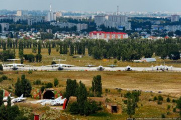 Arched concrete shelters for aircraft and, in the background, aircraft parking and a military training and research center at the Russian Baltimor military airfield in Voronezh.