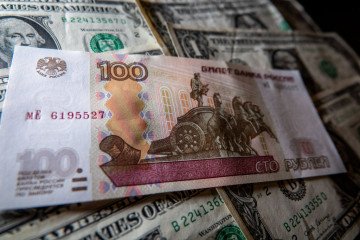 In this photo illustration, Russian rouble notes are seen besides one Dollar bill notes. (Source: Getty Images)